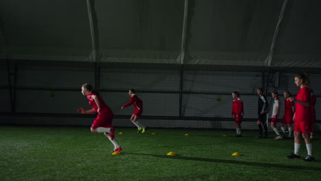 young female soccer players practice their skills indoors