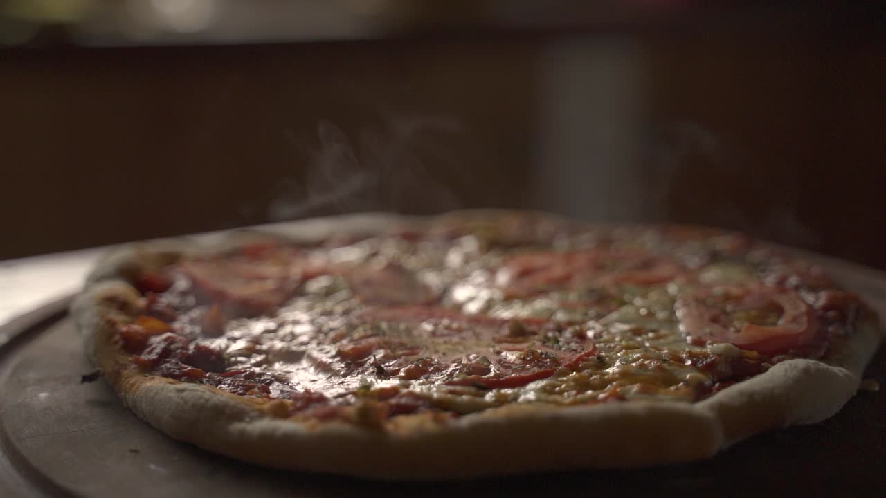 Close up of Delicious smokey home made pizza on a wooden plank Slow Motion 60FPS