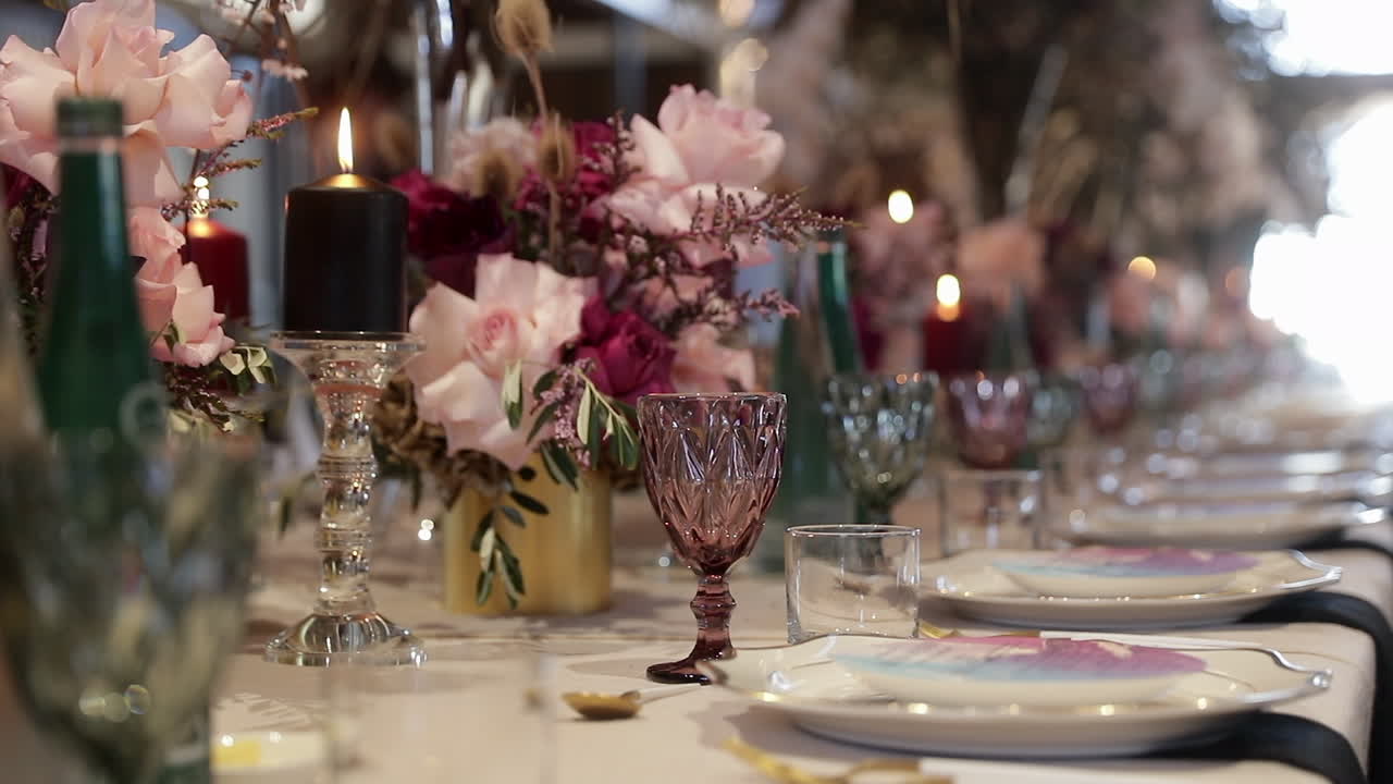 Panning showing the glassware and decorations used on a table at a wedding reception