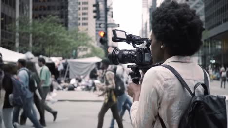 documenting urban life: a videographer captures the vibrant energy of a busy city street and the diverse crowd navigating through the scene