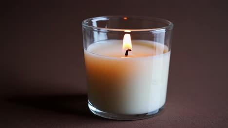 close-up of a lit candle in a glass jar