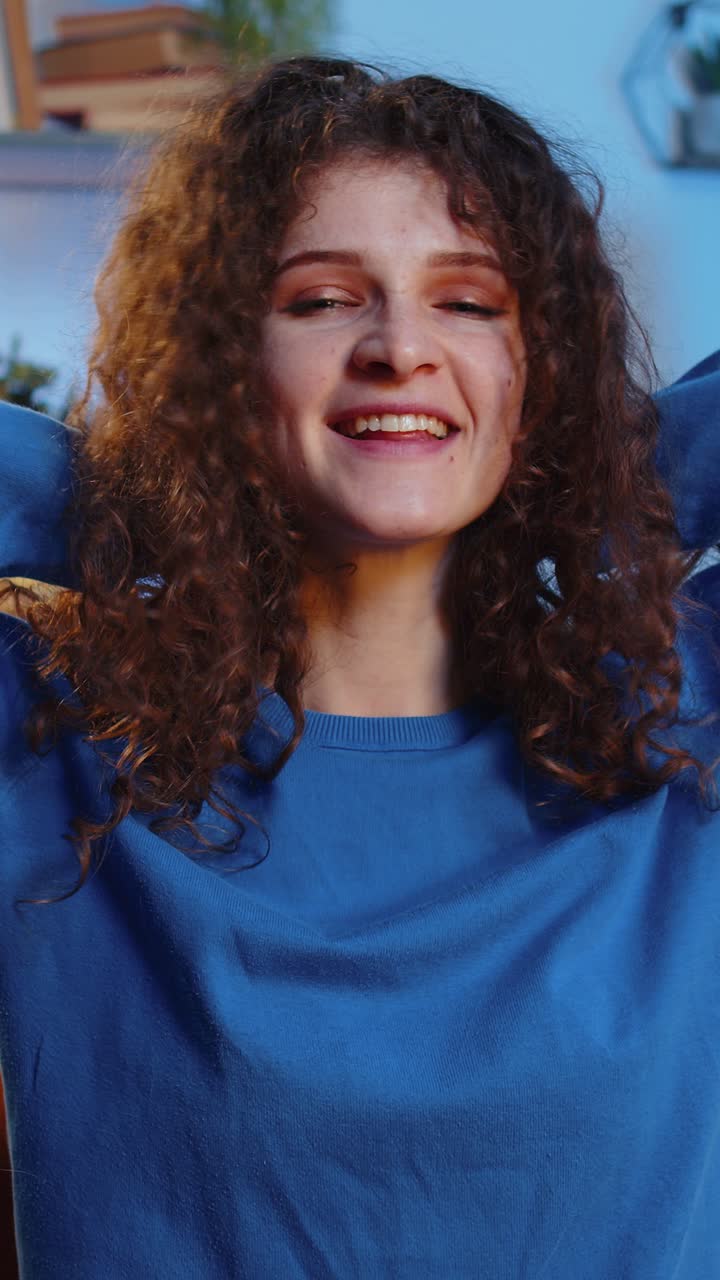 Ritratto di una giovane donna allegra e sorridente, che gioca e si sistema i capelli mossi