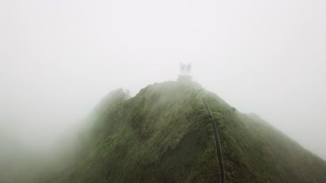 aerial shot of clouds rolling over the top of the haiku stairs trail, or stairway to heaven, on oahu.