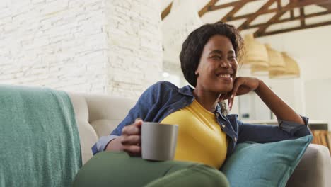 Video-Einer-Glücklichen-Afroamerikanischen-Frau-Auf-Dem-Sofa,-Die-Fernsieht