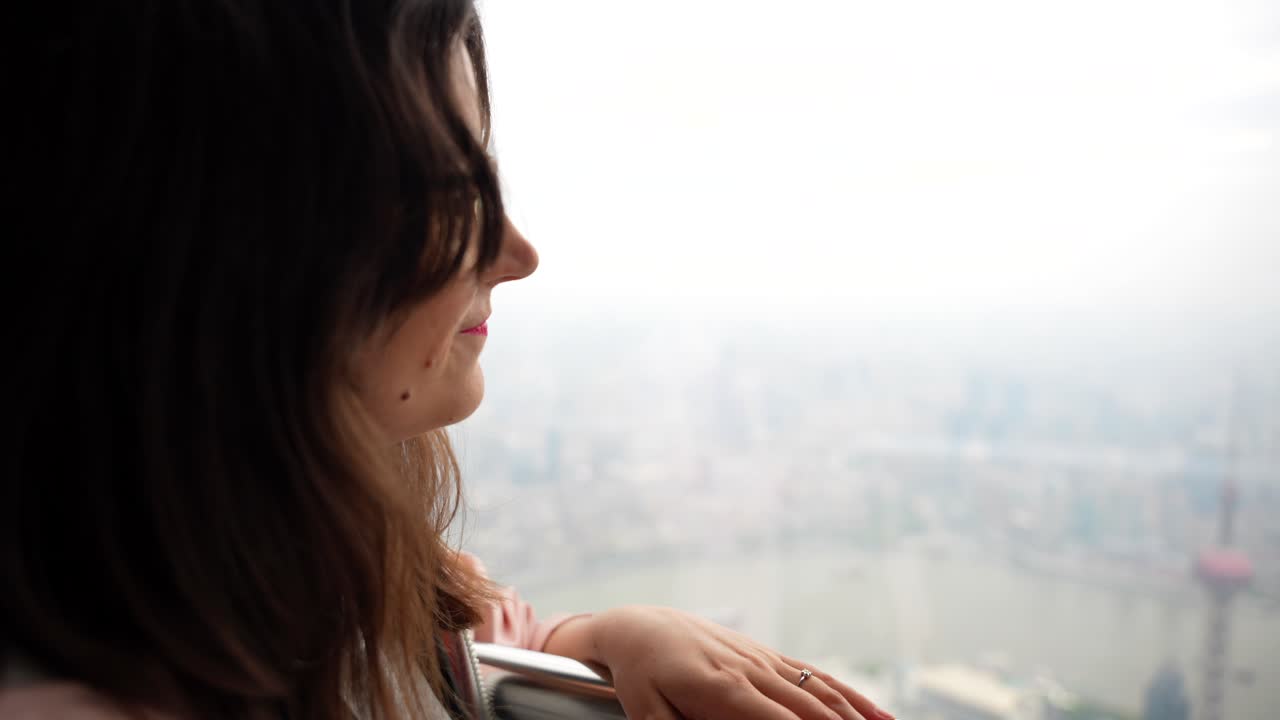 Donna che si gode la vista da un'alta piattaforma di osservazione. Shanghai, Cina