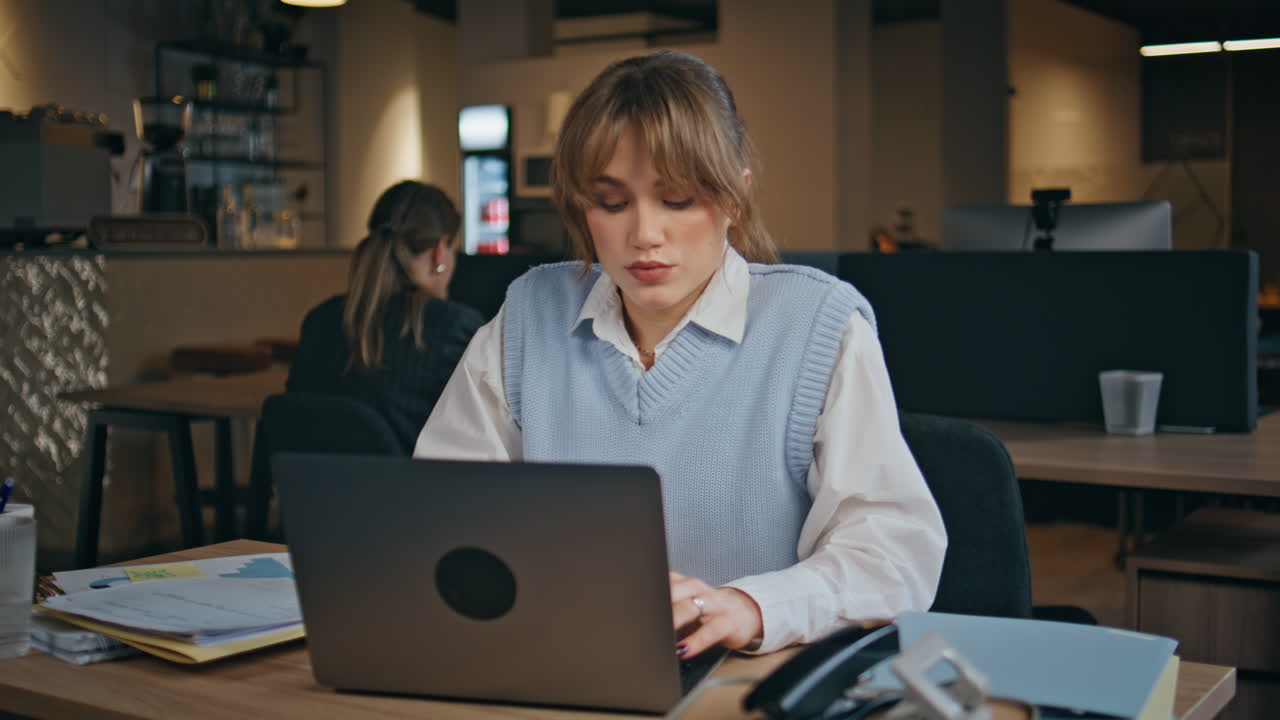 Primo piano di una donna d'affari concentrata che digita sul portatile in ufficio. Ragazza che guarda il computer
