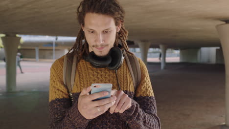 portrait of young mixed race man texting on phone happy relaxed