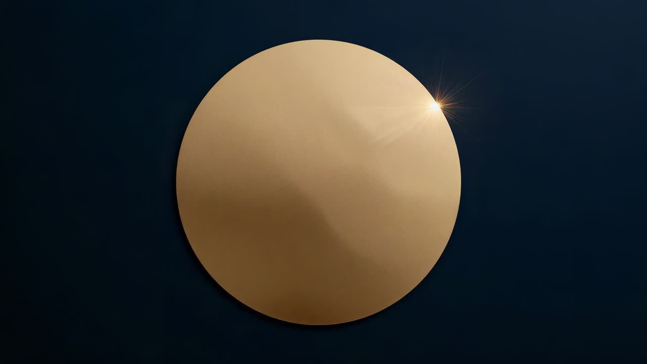 Glint appearing on gold metallic disk forming starburst and streak at navy backdrop for logo reveal