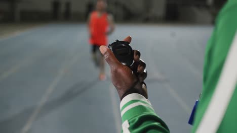 Hand-of-african-american-male-coach-checking-time-of-disabled-male-athlete-with-running-blade