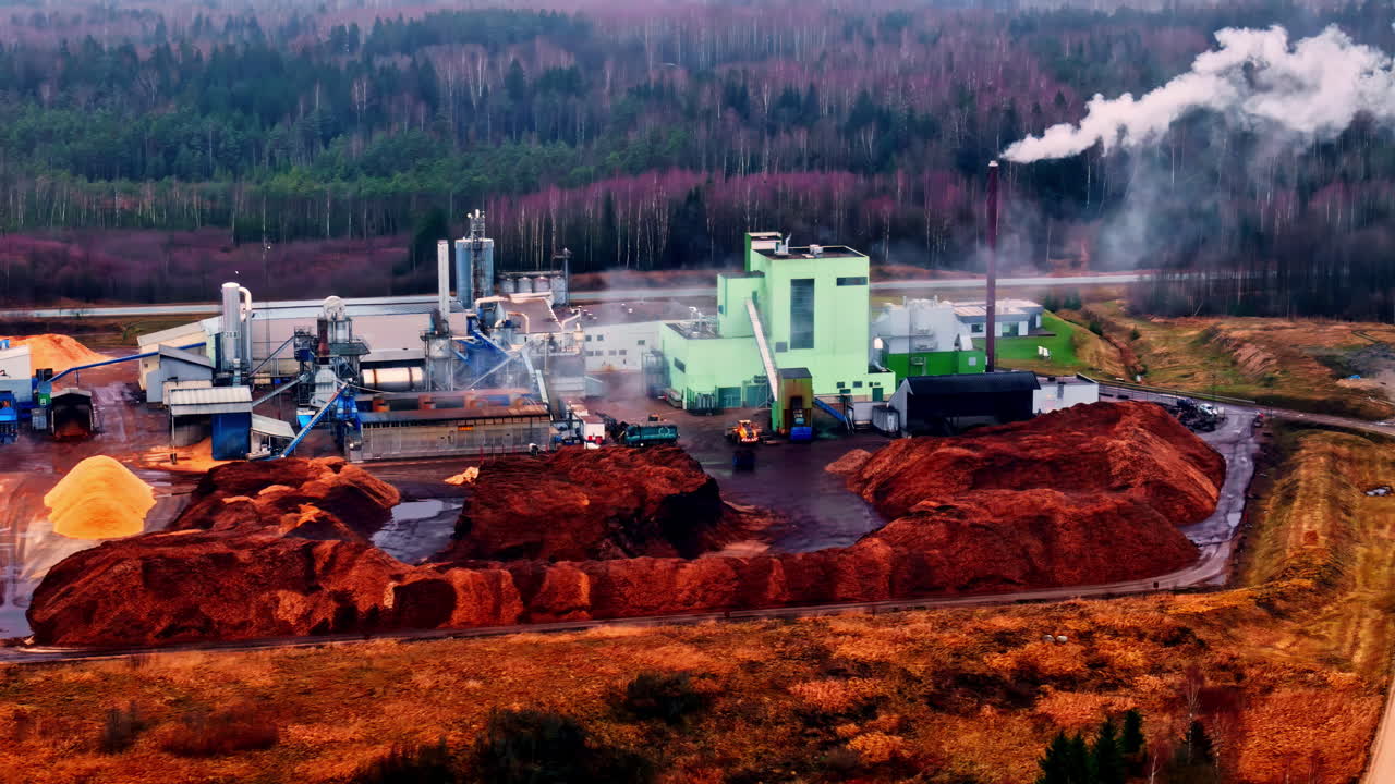 Stabilimento industriale a Cesis, in Lettonia, sotto un cielo nuvoloso con fumo che si alza