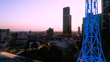 Aguja-De-Arte-De-Melbourne-Resaltada-Con-Neón-Azul-Que-Brilla-Contra-El-Hermoso-Horizonte-De-La-Ciudad-Al-Atardecer