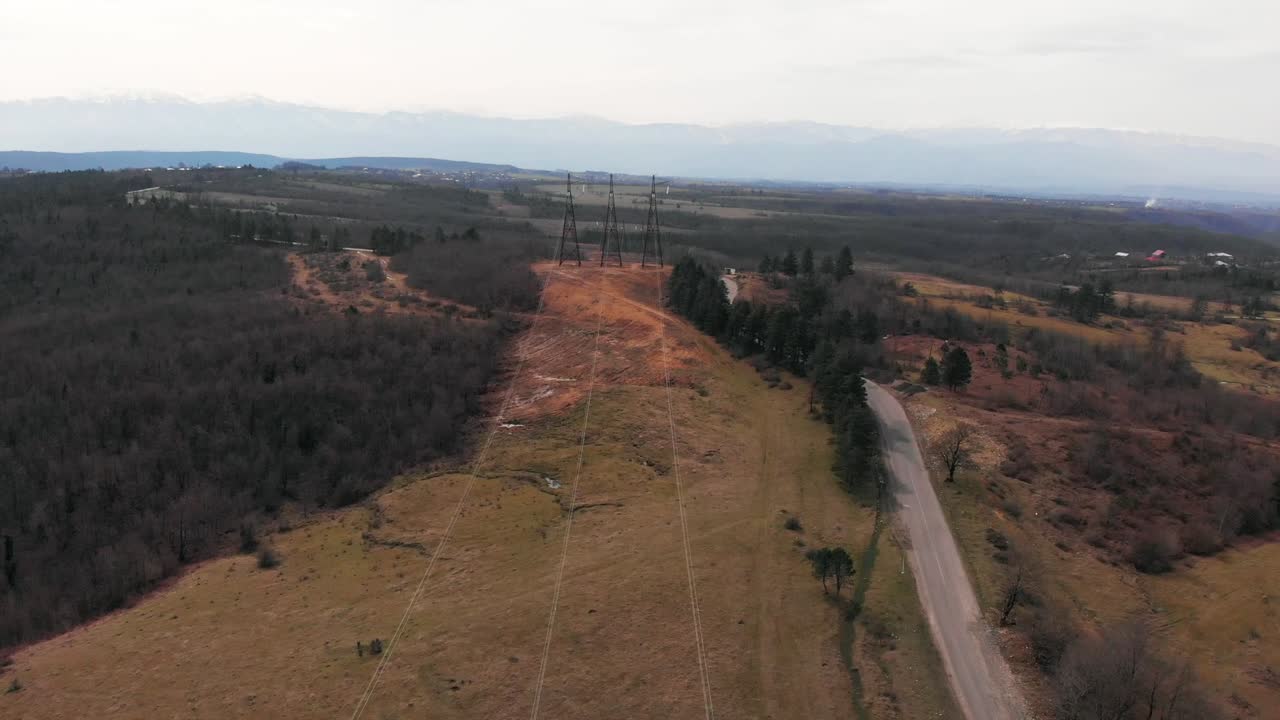 Aerial footage of electric high voltage power transmission towers on a field 2