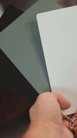 skilled photographer uses cards to adjust contemporary camera before shooting in light restaurant hall closeup. cameraman at work at photo session