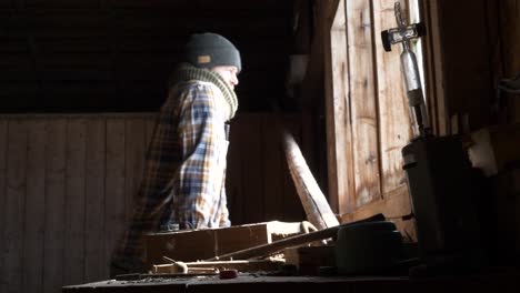 un joven con sombrero en su laboratorio mira por la ventana y prepara una caja de herramientas.