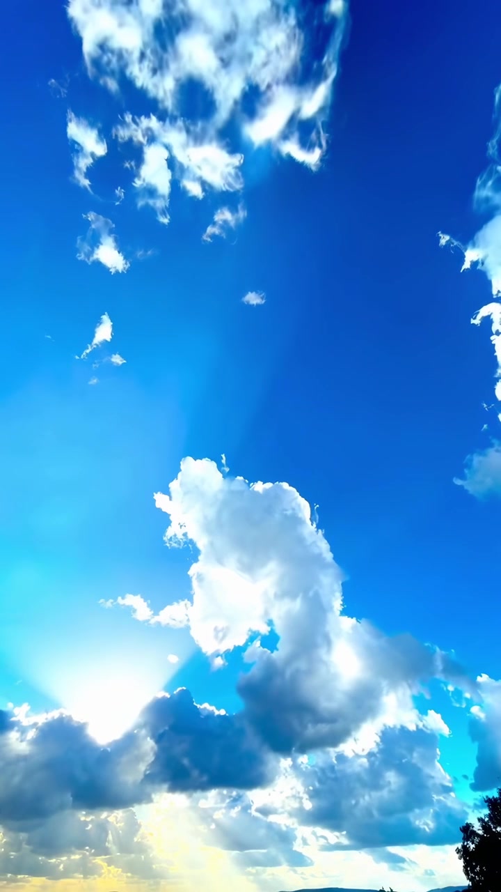 Sinar Matahari Menembus Awan di Langit Biru Cerah