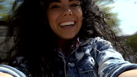 happy brunette spinning around herself with camera in hands