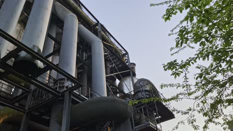 Large-old-pipes-of-an-industrial-building-in-the-evening-mood-of-the-Landscape-Park,-Duisburg,-Germany