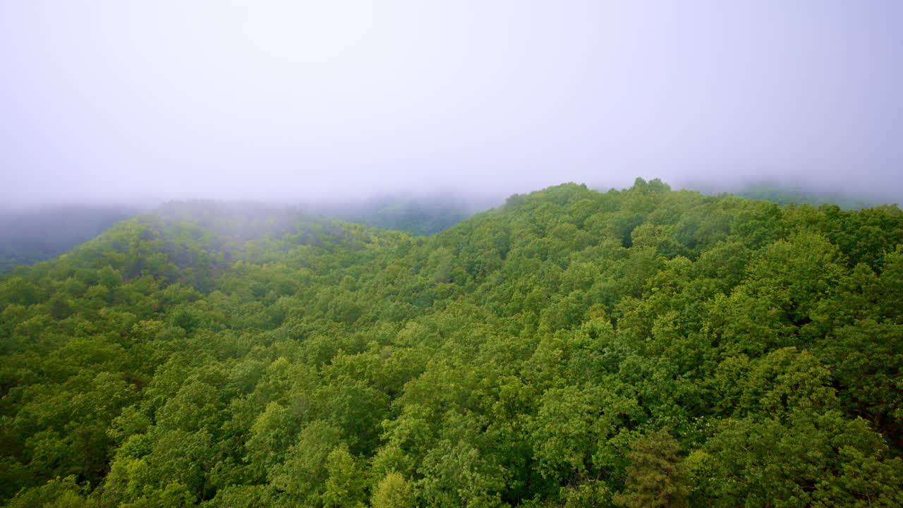 Aerial drone shot with fog drifting across mountain tops