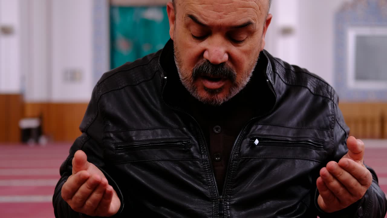 anciano levantando las manos y rezando en la mezquita 1