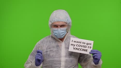 doctor in suit with syringe, ampoule and text slogan on paper - i wand to get my covid-19 vaccine