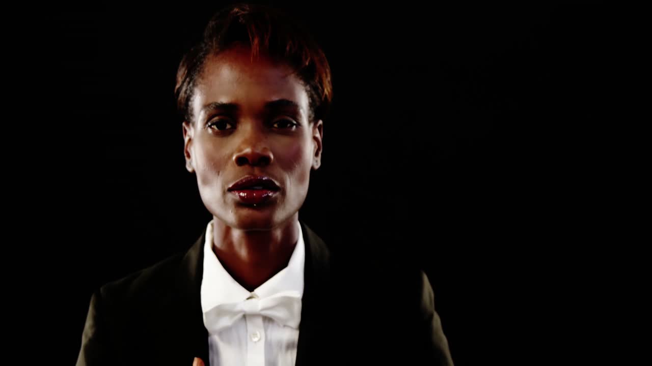 회색 배경을 배경으로 포즈를 취하는 양복을 입은 남성