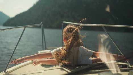 calm girl and boy straighten arms to sides sailing on motorboat on sea on sunny day. siblings relax enjoying stunning view in summer. observing beauty of nature