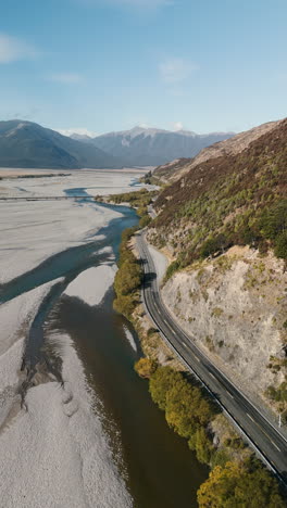 aerial view of winding road along a river valley in new zealand