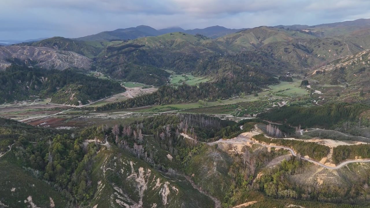 Byen Marahau, der viser stier der snor sig gennem bjergrigt skovlandskab i Abel Tasman National Park, Sydøen, New Zealand. Panoramisk droneudsigt fra luften