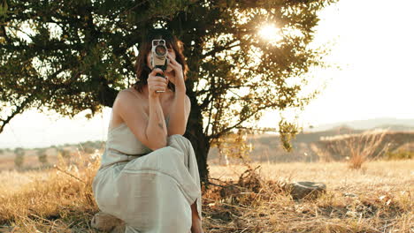 woman holding vintage camera outdoors