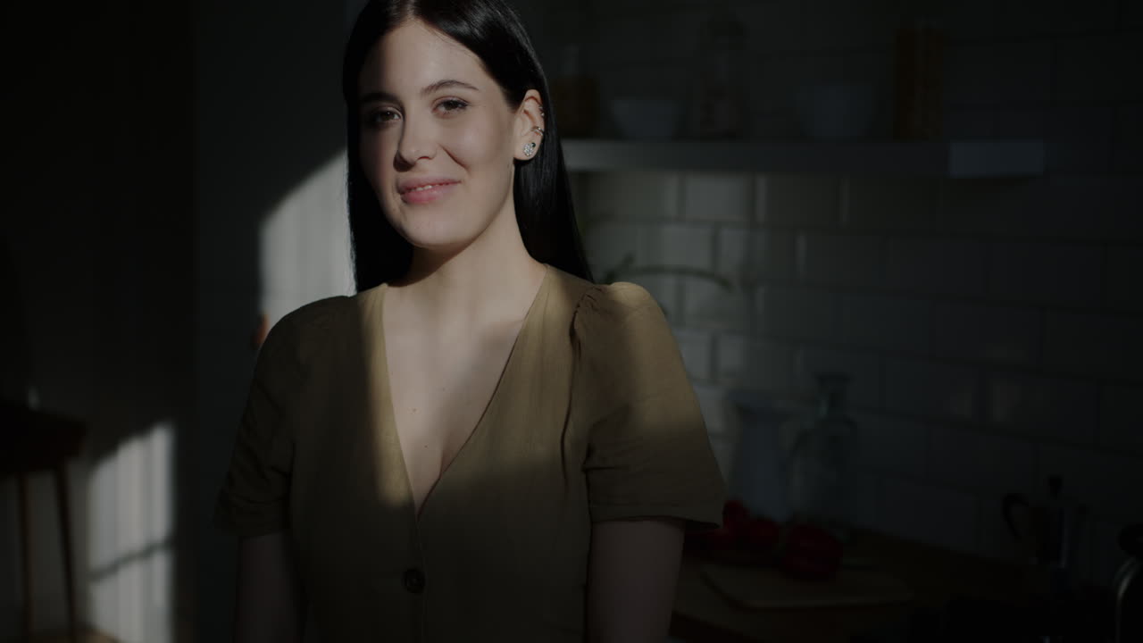 Woman Smiling in Kitchen with Sunlight
