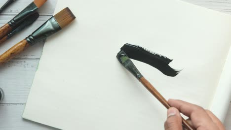 artist painting with black paint