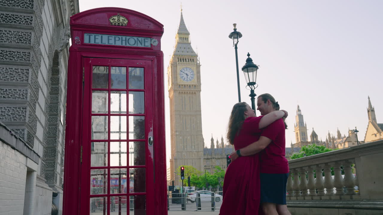 In Love Couple Dancing And Kissing Next To Red Telephone Box In London, United Kingdom. - wide shot