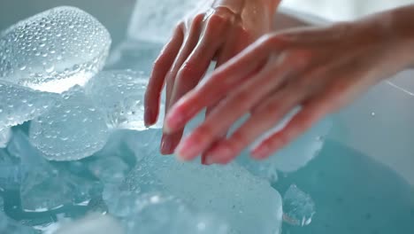 woman's hands touching ice cubes