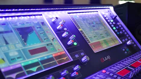 a close-up view of the vibrant screens on an audio mixer, displaying intricate sound waveforms and levels