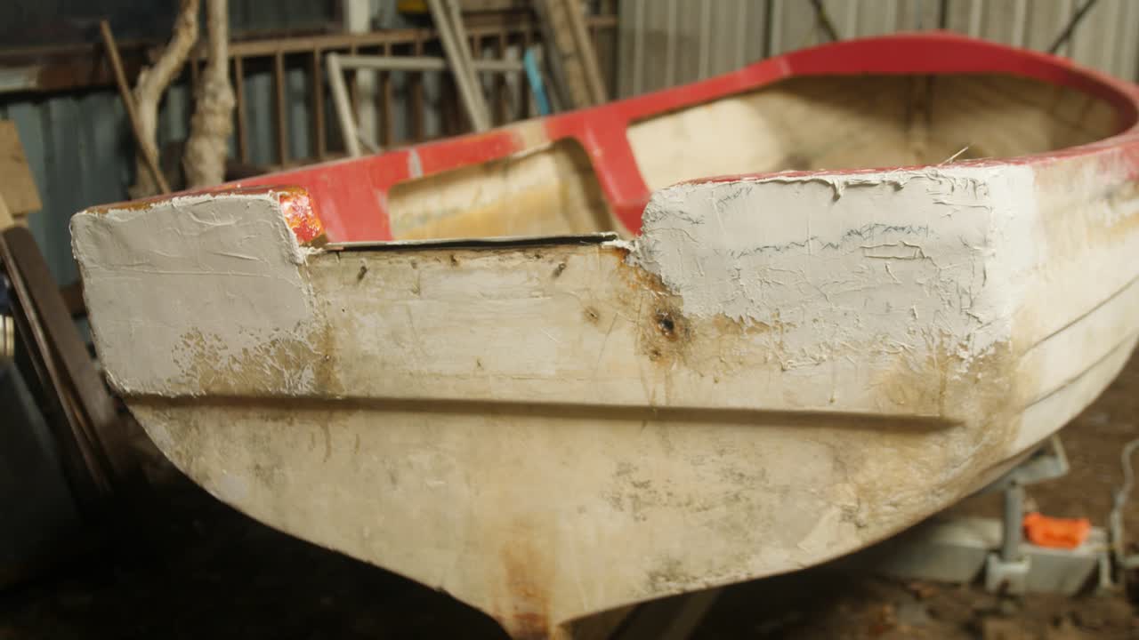 Utilizzo di una pistola termica su una riparazione con stucco poliestere sullo specchio di poppa di una barca da pesca