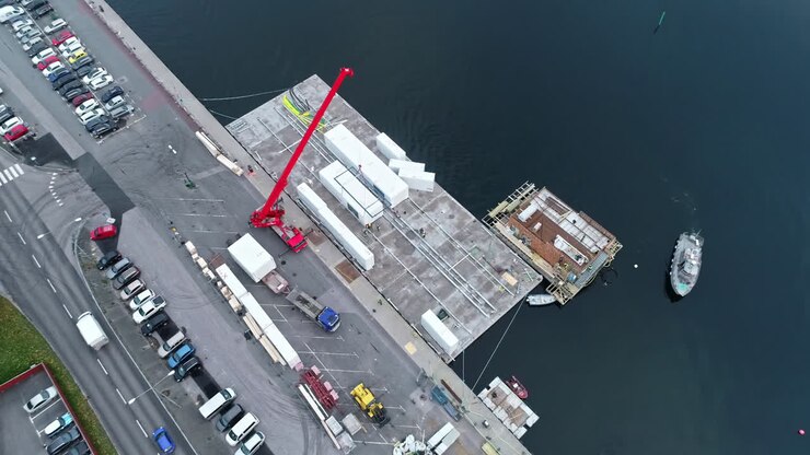 An Aerial Shot Of A Ship Approaching A Harbor That Is Located Near A Driveway