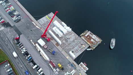 an aerial shot of a ship approaching a harbor that is located near a driveway