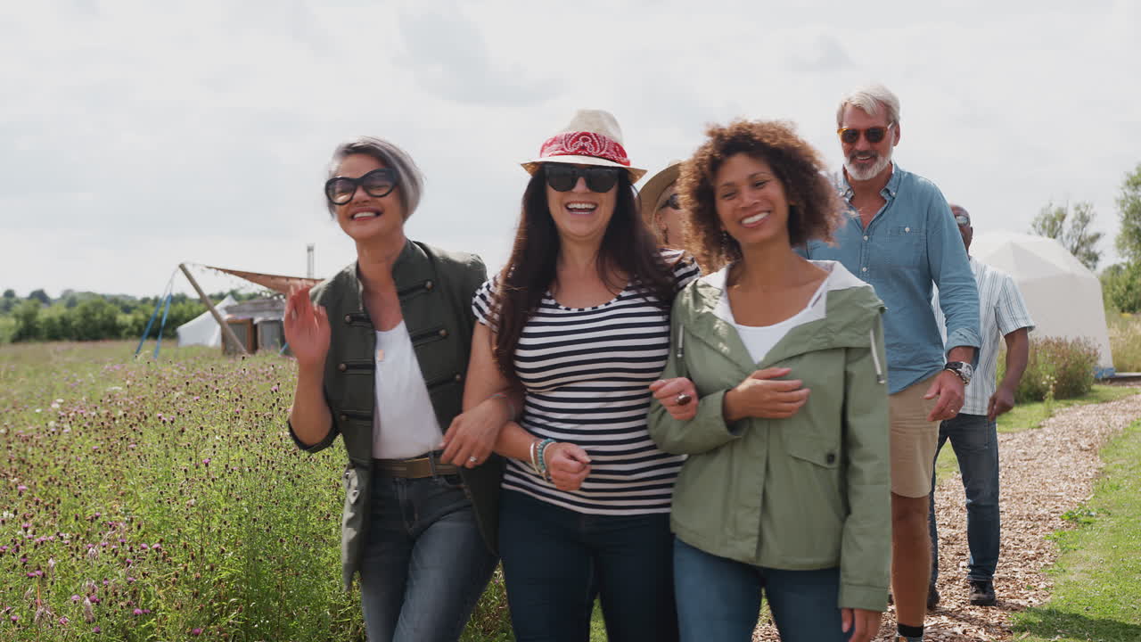 성숙 한 친구 들 의 그룹 이 유르트 캠핑장 을 가로지르는 길 을 따라 고 있다
