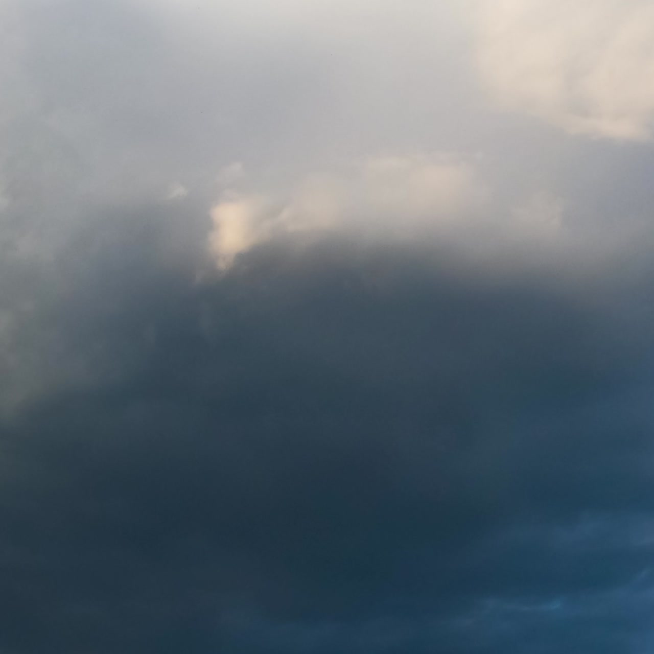 Grey rainy clouds spreading by the sky. Rain formation in the atmosphere. Low angle view timelapse
