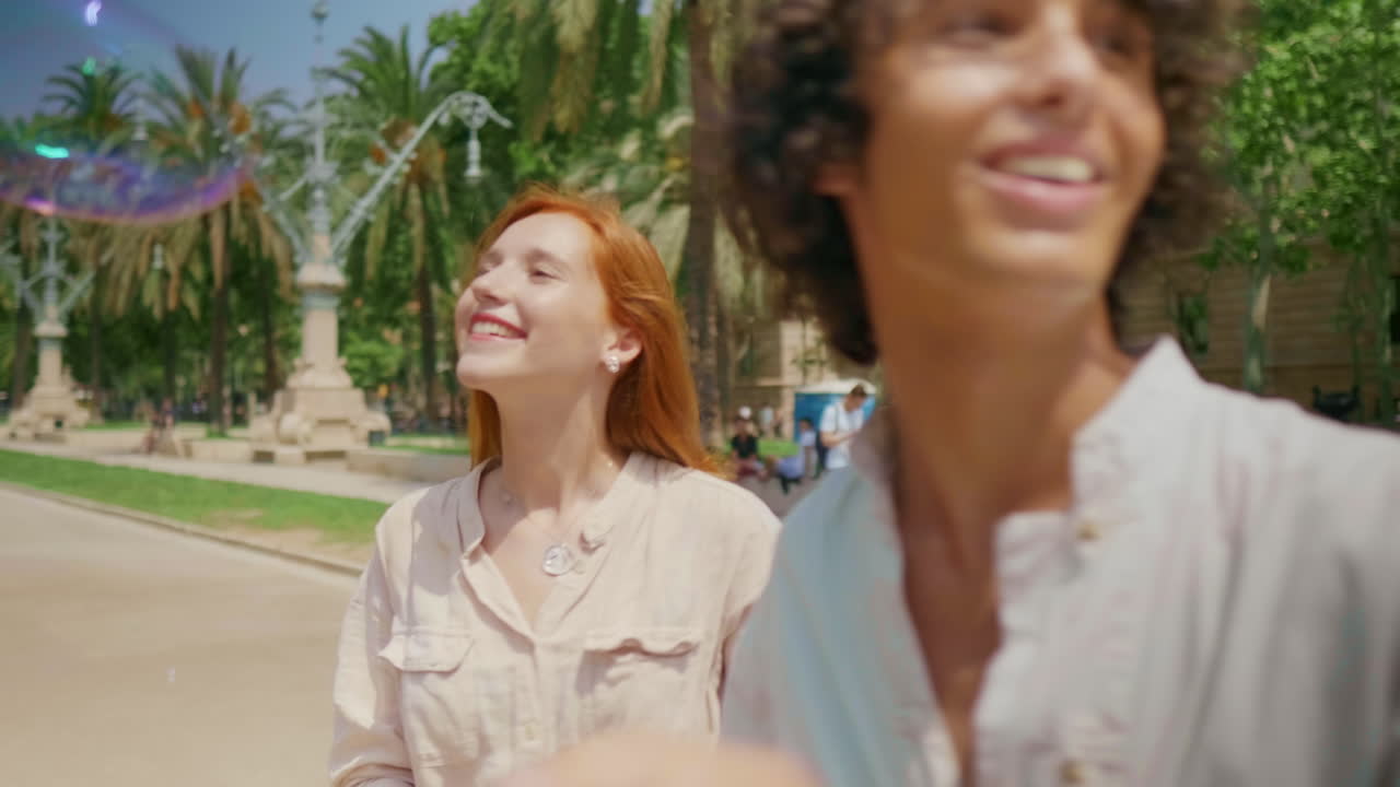 가까이 찍은 귀여운 커플이 비누 거품을 잡고 있다. 웃는 가족이 거품으로 놀고 있다