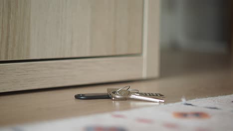 keys on the floor near a cabinet