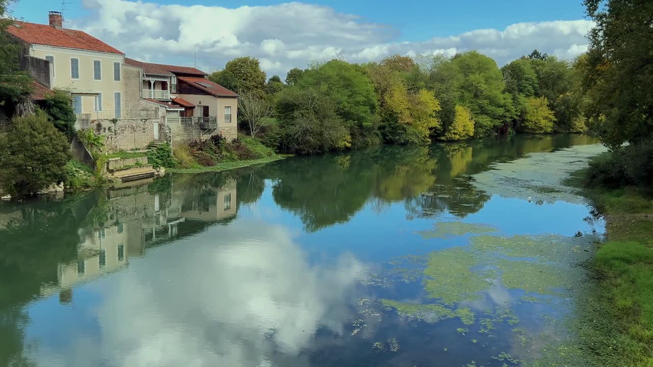 Calm reflective scene of blue sky and cloud in the river l’Adour in France