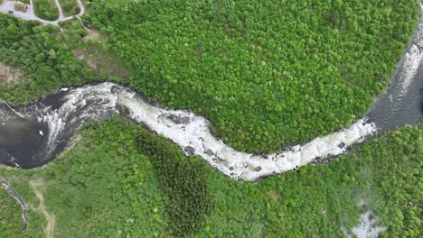 Rauma-river-flowing-through-Romsdalen-valley-close-to-Trollveggen-mountain-in-Norway---Top-down-birdseye-aerial-of-river-with-green-forest-on-both-sides