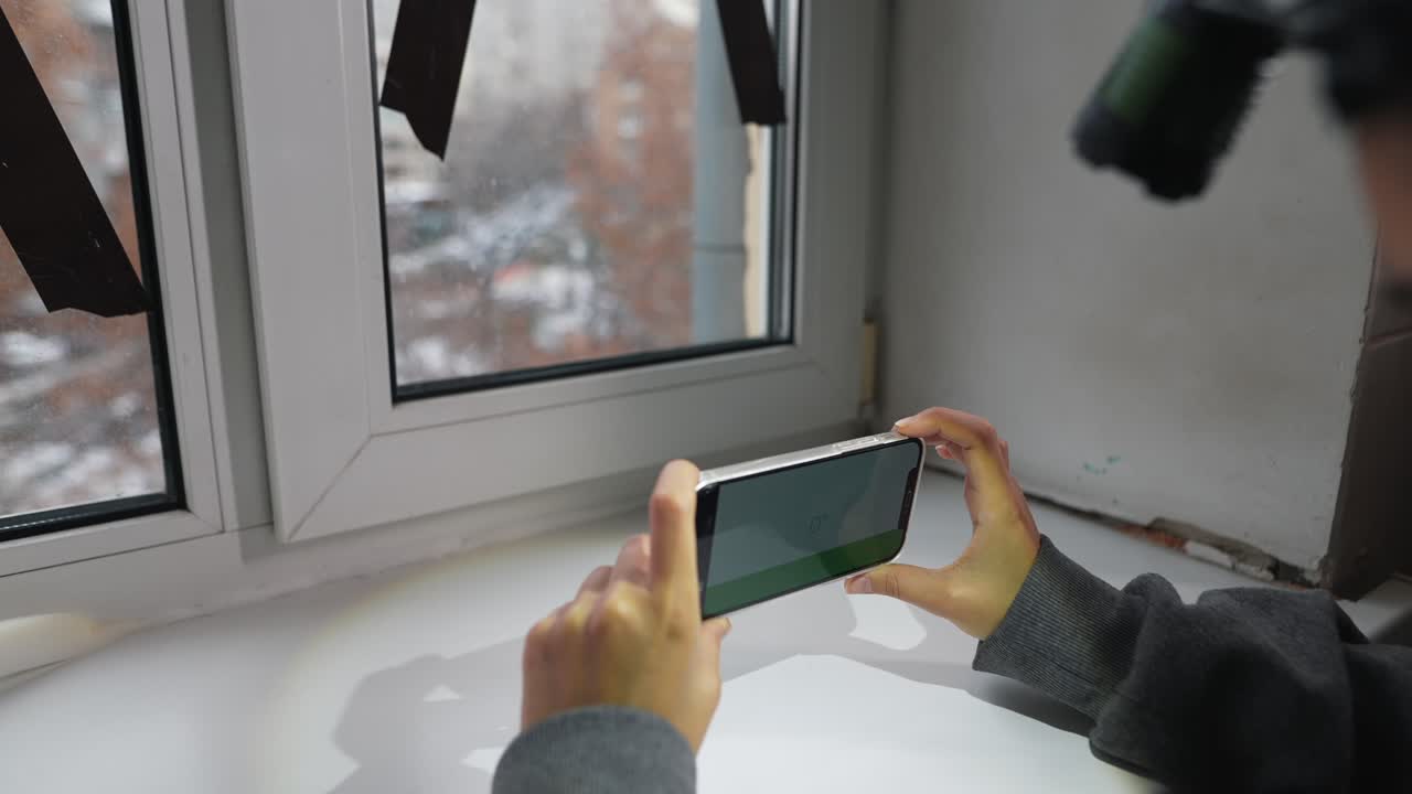 persona con teléfono cerca de la ventana