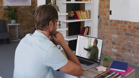 Caucasian-male-student-using-laptop-on-video-call-with-male-teacher