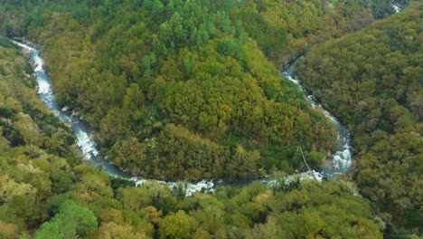 drone view of a river in lush valley at fervenza do toxa in pontevedra, galicia spain