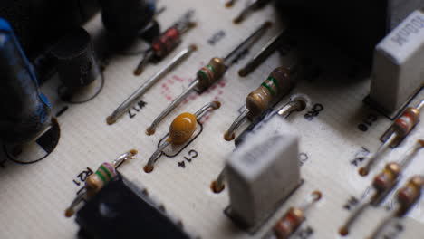 many old dusty resistors on a retro circuit board controller with other electronic components and plugs