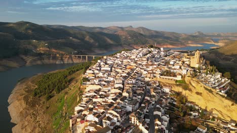 Pueblo-De-Montaña-Blanco-De-Iznajar-Y-Depósito-De-Agua-En-Andalucía,-España---Pedestal-Aéreo-4k-Arriba