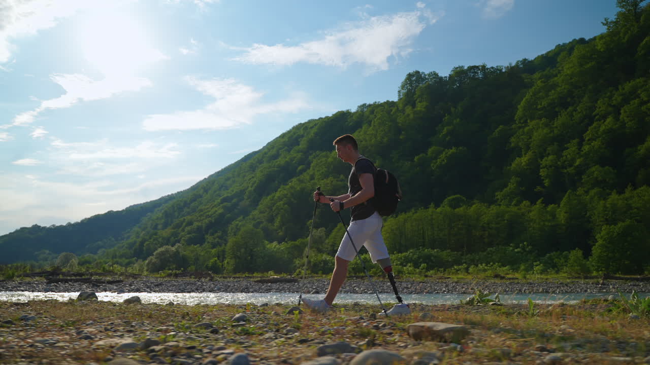 hombre con pierna protésica caminando por las montañas