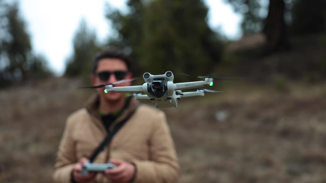 Man operating a DJI Mini 3 Pro drone outdoors